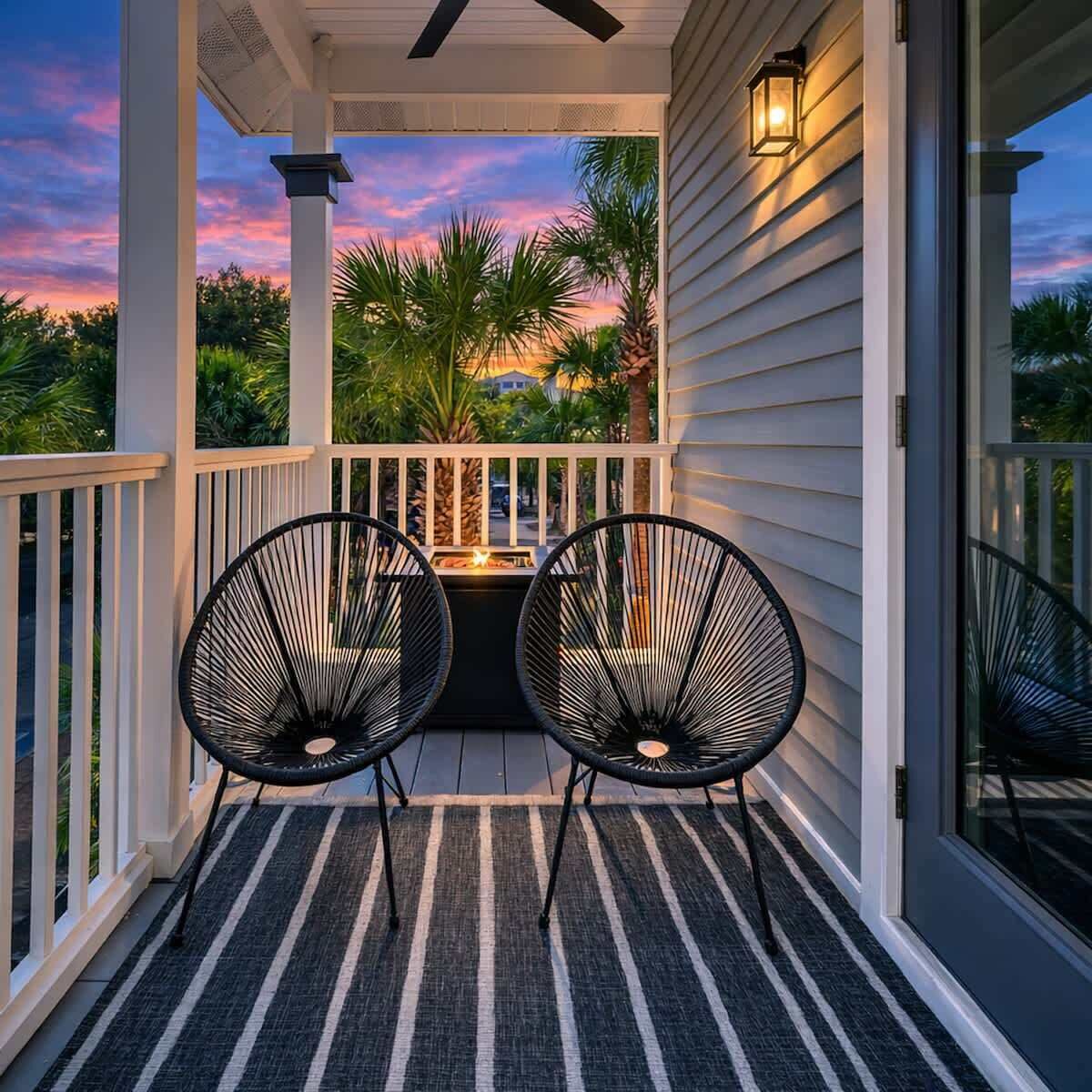 Een veranda met twee stoelen, een tafeltje en een leuning.