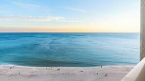 Uitzicht op een strand met heldere lucht en een rustige zee.