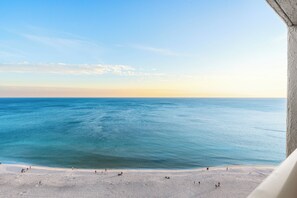 Blick auf einen Strand mit blauem Himmel und ruhiger See.