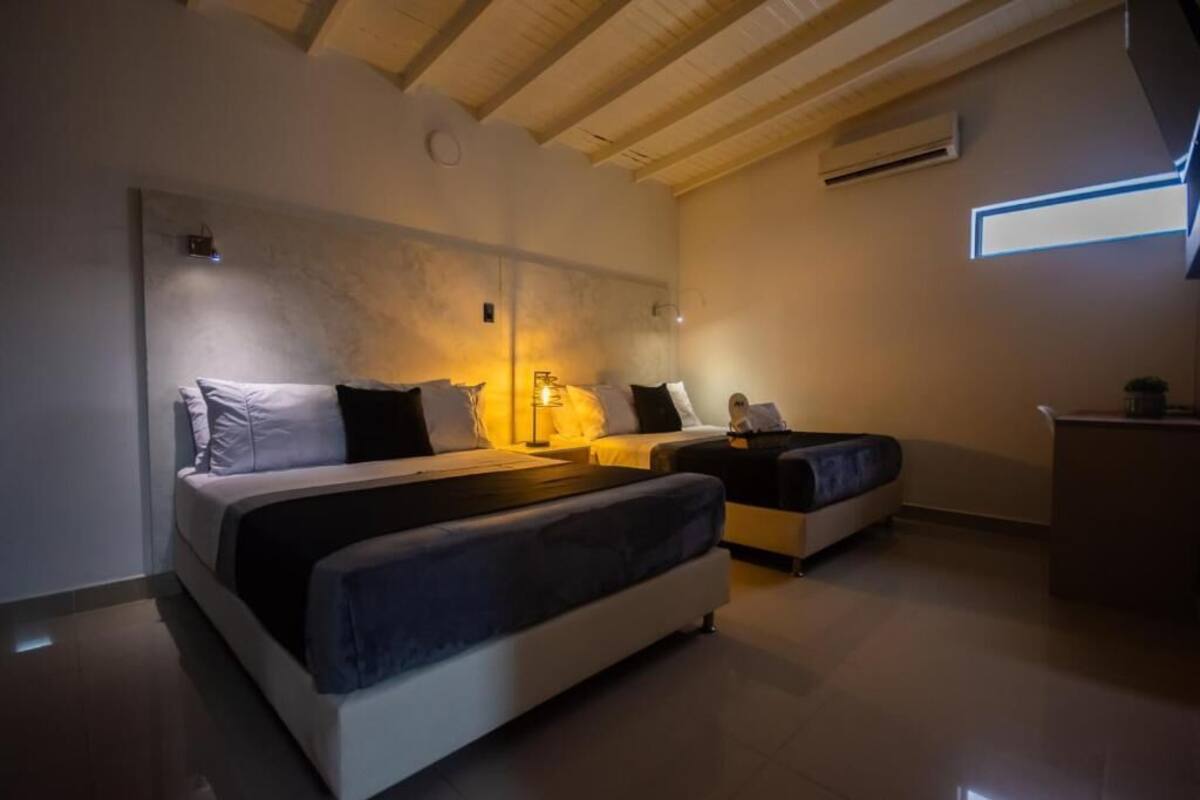 Um quarto moderno com uma cama grande, uma cama menor e uma escrivaninha.