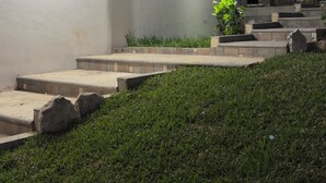 Un edifici modern amb teulada plana, una finestra gran i façana de pedra.