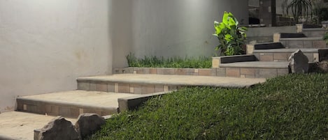 Un edificio moderno con tejado plano, un ventanal grande y fachada de piedra.
