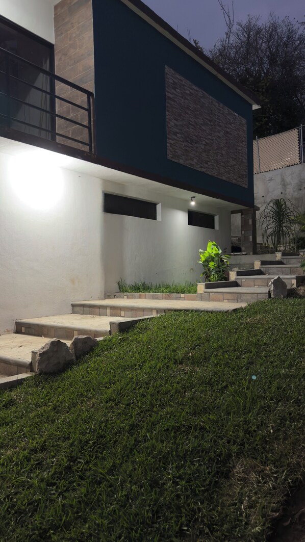 Un edificio moderno con tejado plano, un ventanal grande y fachada de piedra.