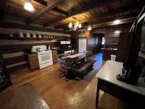 Una cocina rústica con vigas de madera, una isla central y electrodomésticos integrados.
