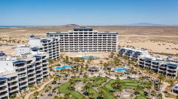 A resort with multiple buildings, a central pool, and a golf course. - Casa Blanca Villa 9 | 3BR Condo | Sleeps 6 (Puerto Peñasco)