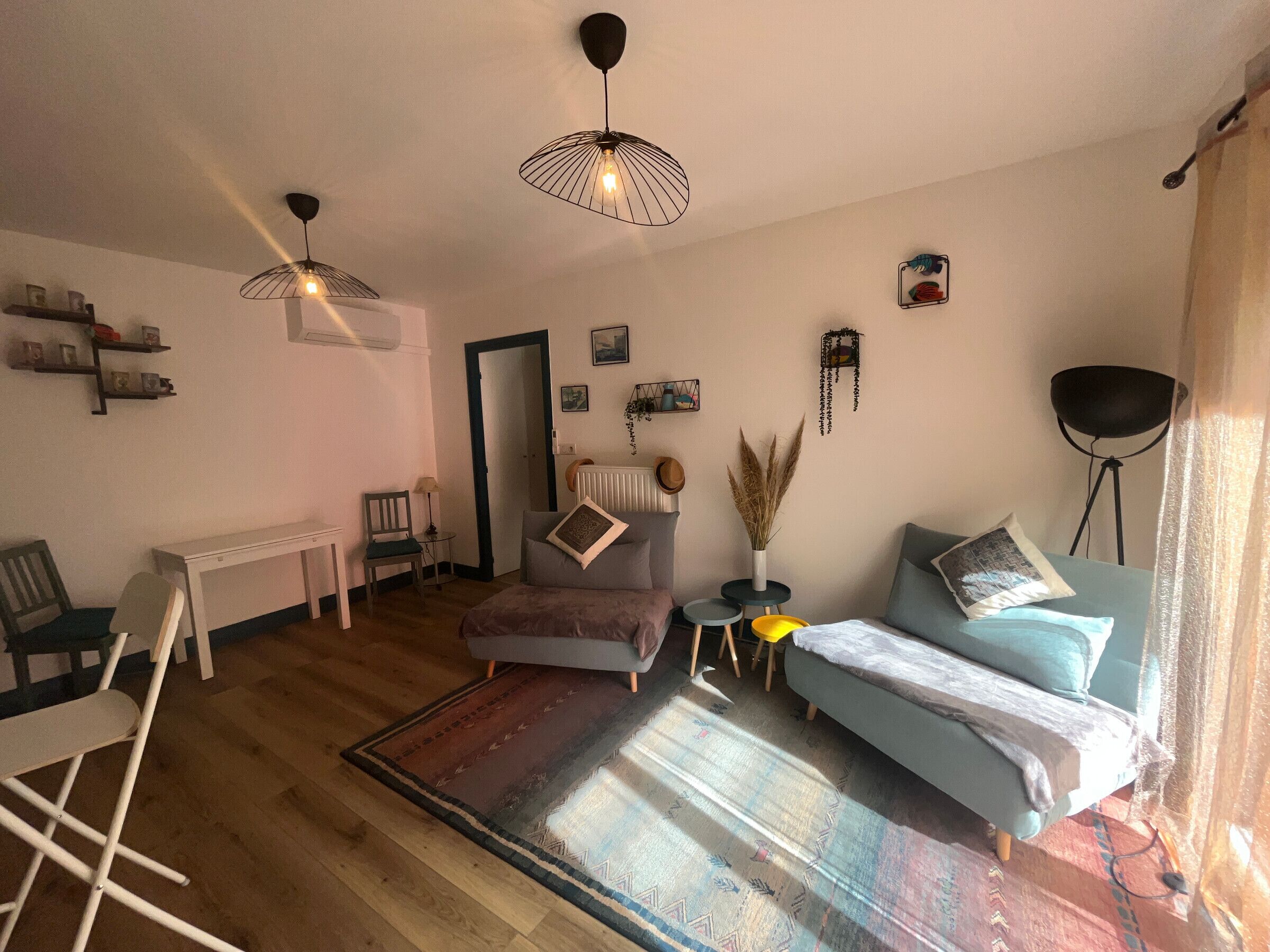 A cozy room with a bed, a desk, a chair, and a floor lamp.