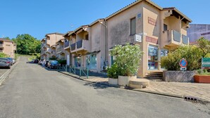 A row of residential buildings with balconies, a visible laundry service sign, and a clear sky. - Studio in Barbotan-les-Thermes, Wi-Fi, Pets Allowed (Barbotan-les-Thermes)
