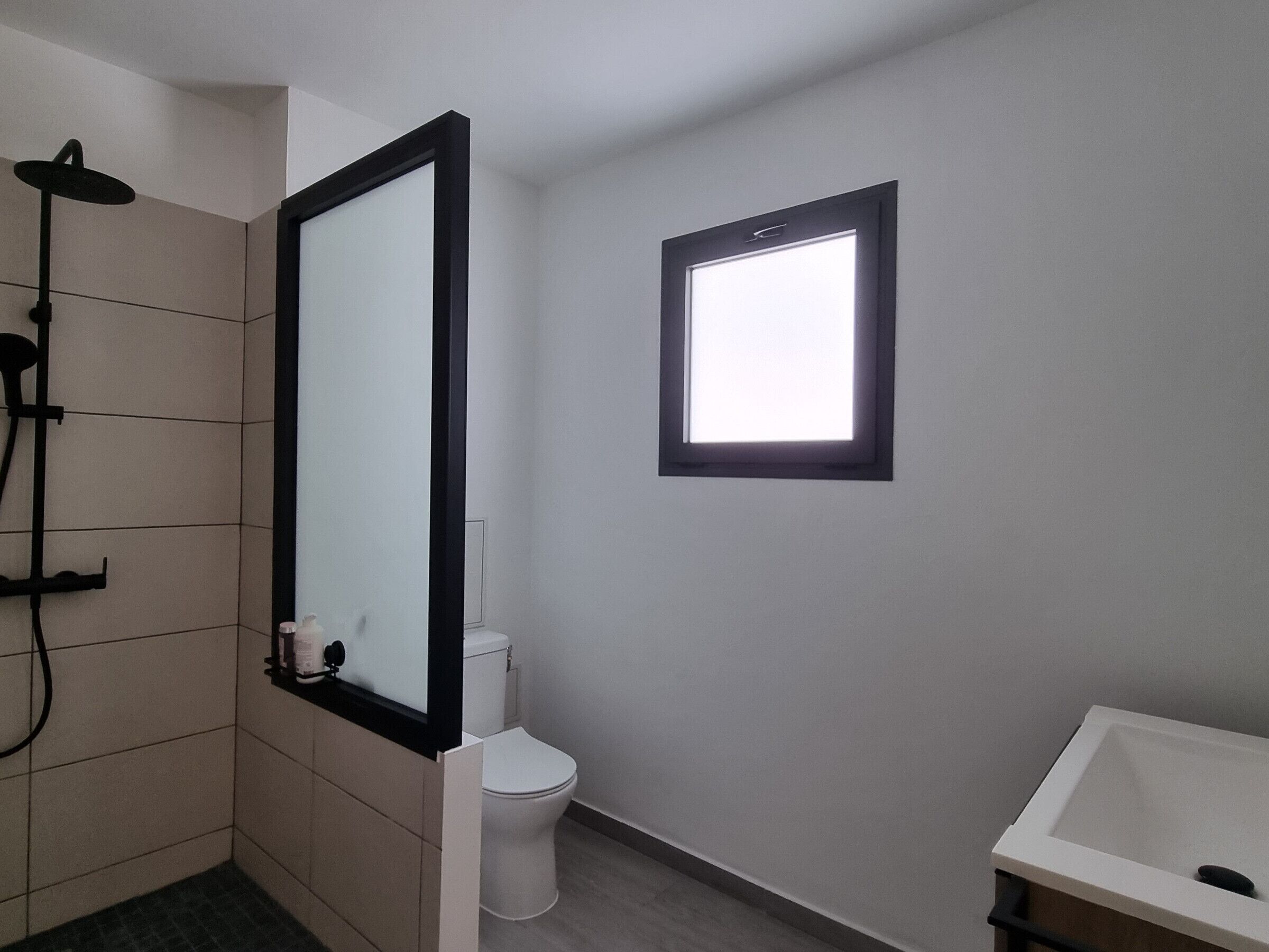 A bathroom with a shower, toilet, and sink.