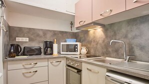 Eine moderne Küche mit Mikrowelle, Toaster, Kaffeemaschine und Geschirrspüler.