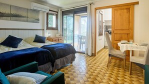 Ein Zimmer mit zwei Betten, einem Schreibtisch, einem Stuhl und Blick ins Freie.