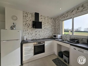 A modern kitchen with a microwave, oven, and dishwasher. - House with pool and AC - 4 guests (SAINT LAURENT DES HOMMES)