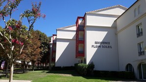 A building with a sign reading "RESIDENCE PLEIN SOLEIL" indicating a residential complex. - Studio, pets welcome, near city center (Lamalou-les-Bains)