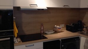 Eine Küche mit Holzausziehtisch, Spüle, Mikrowelle und Geschirrspüler.