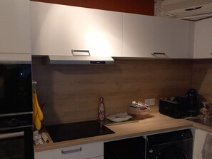 A kitchen with a wooden countertop, a sink, a microwave, and a dishwasher. - Charming 2BR with AC and Private Parking - Beachfront for 4 pers (Sète)