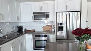A modern kitchen with white cabinets, stainless steel appliances, and a central island. - Cozy 1-bedroom apartment in delightful Downtown Los Angeles with AC and gym (Los Angeles)