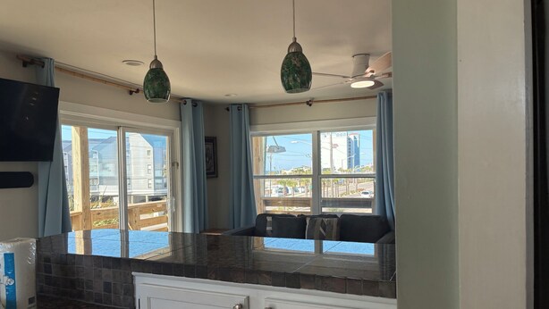 A kitchen with a window view, a ceiling fan, and a hanging light fixture. - Downtown Gulf Shores Beach -Best Spot in Complex W/Panoramic Views-Pet Friendly (Gulf Shores)