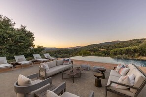 An outdoor seating area with a pool, lounge chairs, and a sofa. - Luxury Modern Home w/ Infinity Pool - 3400 sq ft (Fetters Hot Springs-Agua Caliente)