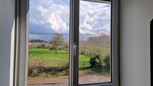 A window with a view of a green field and trees. - Ideal for professionals on assignment (Festubert)