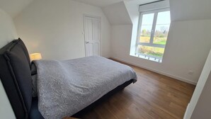 A bedroom with a bed, a window, and a door. - Ideal for professionals on assignment (Festubert)