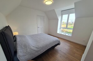 Une chambre à coucher avec un lit, une fenêtre et une porte.