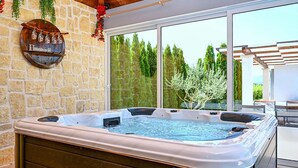 Ein Whirlpool mit Steinwand und Blick auf Bäume.