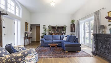 A living room with a sectional sofa, a round coffee table, and a patterned rug.