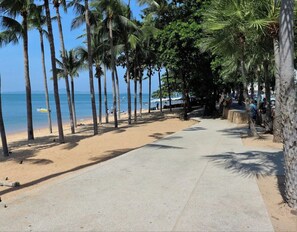 A paved walkway lined with palm trees leading to a beach. - Pattaya studio - ideally located at Jomtien Beach (Muang Pattaya)