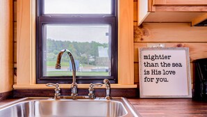 A kitchen with a stainless steel sink, wooden cabinets, and a window with a view. - Family Cabin in the heart of The Pennsylvania Grand Canyon (Wellsboro)