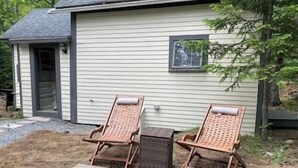 A house with two wicker chairs and a small table in the yard. - Aloft in Acadia National Park (Mount Desert)