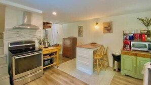 A compact kitchen with a stove, microwave, and refrigerator. - Aloft in Acadia National Park (Mount Desert)