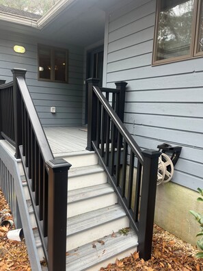 A staircase with black railings leading to a porch area. - Family-friendly, Spacious, One-Level 4-Bedroom Home in Tranquil Southern Shores (Kitty Hawk)