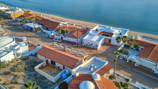Un quartier résidentiel situé sur la côte, avec des immeubles, une plage et une vue dégagée sur la mer.