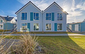 A two-story residential building with a symmetrical facade, multiple windows, and a visible front yard. - Awesome apartment in OstseeResort Olpenitz (OstseeResort Olpenitz)
