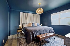 A bedroom with a large bed, a bench, a chandelier, a window, and a nightstand. - Dog’s Perfect Vacation｜54 Acres｜18 min Spring Hill (Columbia)