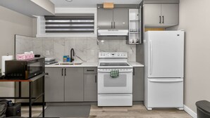 Una cocina moderna con microondas, estufa y refrigerador.