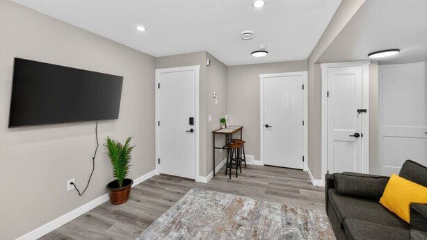 Una sala de estar moderna con un televisor de pantalla plana, una mesa de centro, un sofá y una planta en maceta.