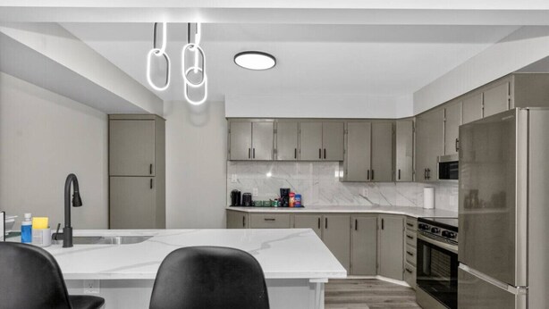Een moderne keuken met een centraal eiland, roestvrijstalen apparatuur en een minimalistisch design.