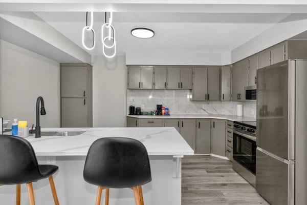 Bright modern kitchen with quartz island, stainless steel appliances, and plenty of space to cook and gather.