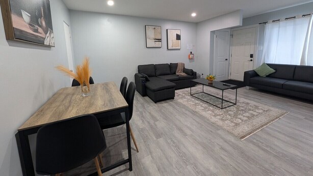 Una sala de estar moderna con una mesa de comedor, sofás y una mesa de centro.