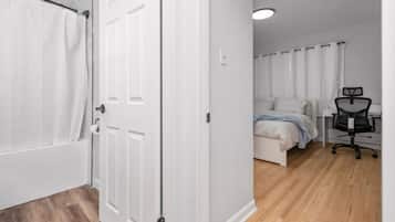 Een slaapkamer met een bed, een bureau en een stoel.