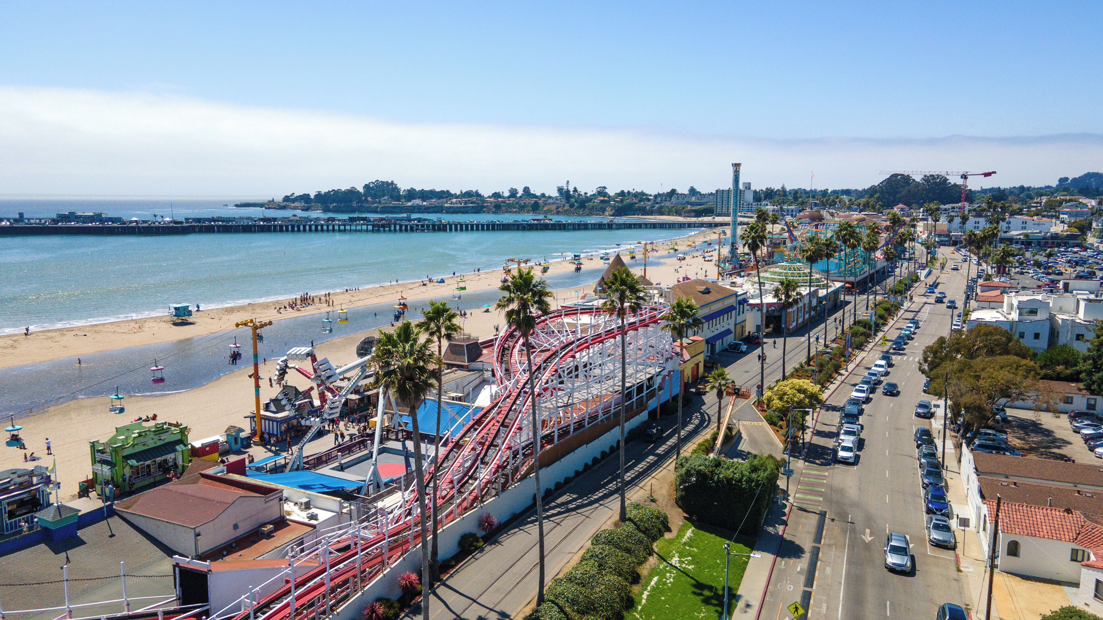 A coastal cityscape with a beach, amusement park, and urban streets.
