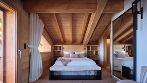 Un intérieur en bois avec un lit, des étagères et un miroir.