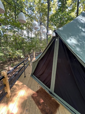 A tent on a wooden deck with a metal railing, surrounded by trees. - Luxury Camping Retreat just 25 min outside of Nashville (Joelton)