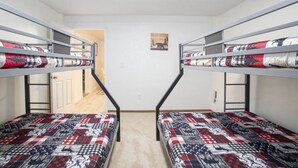 A room with bunk beds, a door, and a small picture on the wall. - Cozy Bear Den Rustic Cabin Central Located (Fairbanks)