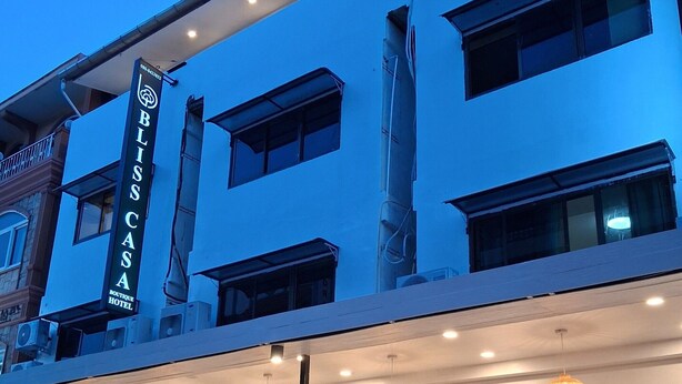 Ein Hotel mit einem gut sichtbaren Schild, auf dem 'BLOSS CASA BOUTIQUE HOTEL' steht, und einem modernen architektonischen Design mit zahlreichen Fenstern und einer Stein-Fassade.