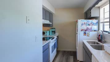 A compact kitchen with a built-in oven, a microwave, and a refrigerator.