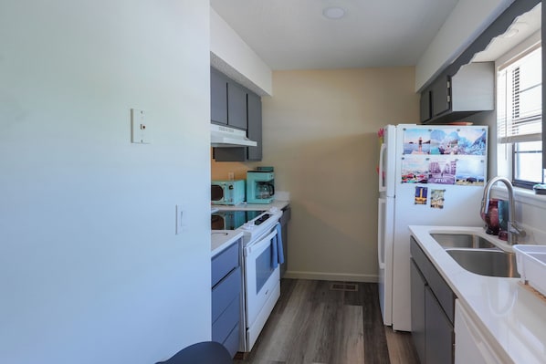 A compact kitchen with a built-in oven, a microwave, and a refrigerator.