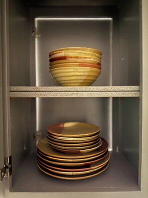 A cabinet with two shelves, each holding a stack of plates.