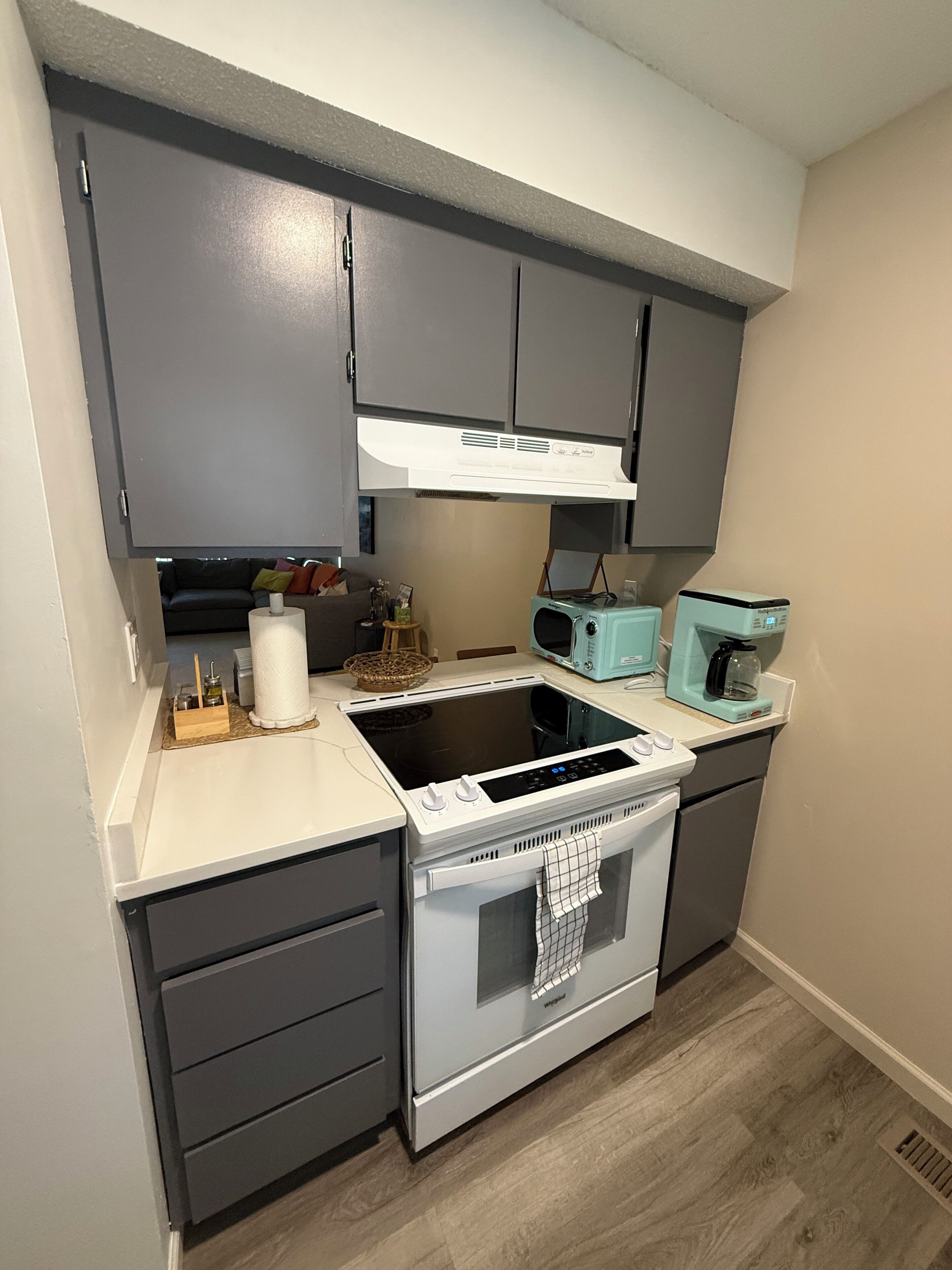 Cocina compacta con estufa integrada, microondas y cafetera.