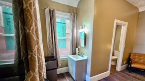 A bathroom with a sink, mirror, and toilet. - Nice large room in Federal Hill (Providence)